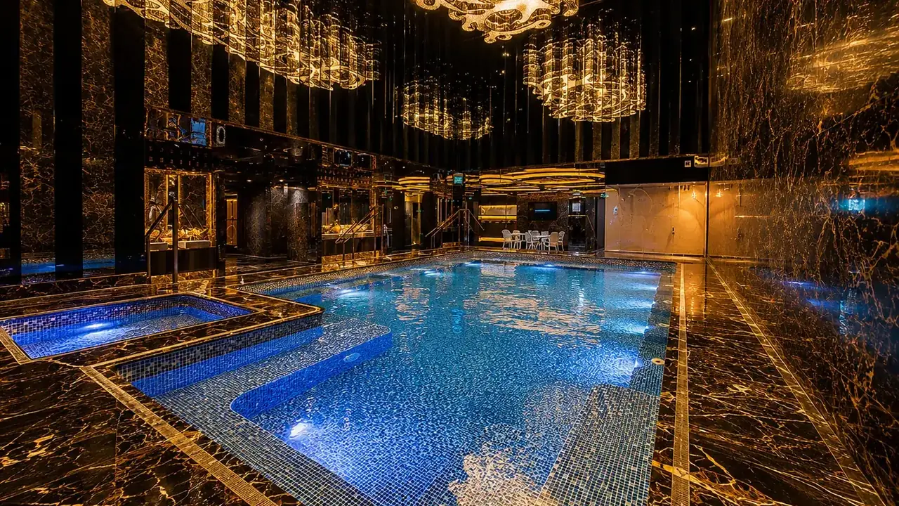 The indoor whirlpool at Majesty Spa, a Macau sauna venue — blue pool water and marble surrounds beneath crystal chandeliers.
